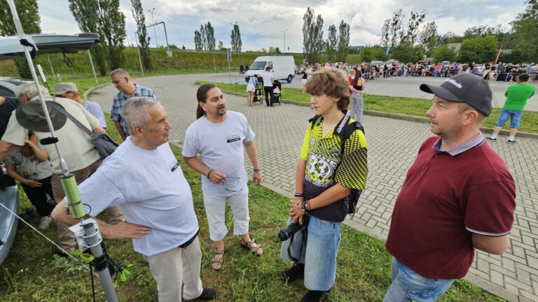 Krótkofalowcy przy maszcie antenowym rozmawiają z gośćmi Spotkania Klasycznej Motoryzacji