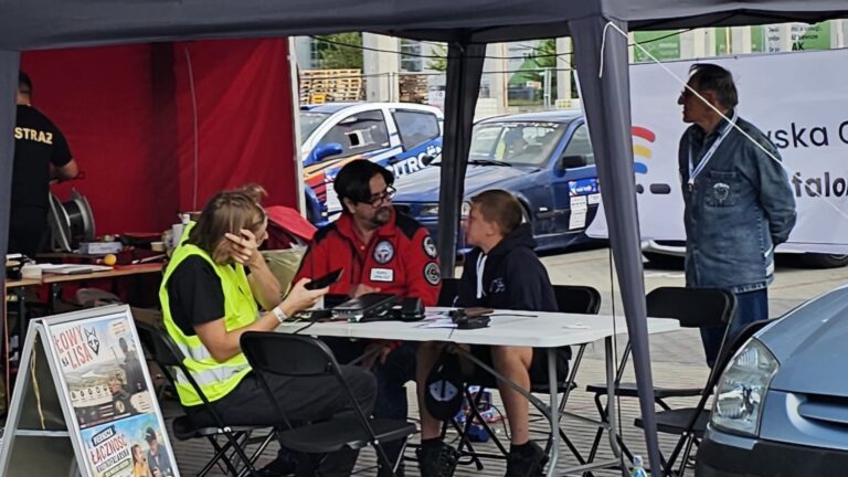 Krótkofalowcy przy stole z radiostacjami pod namiotem na torze Super Sprintu